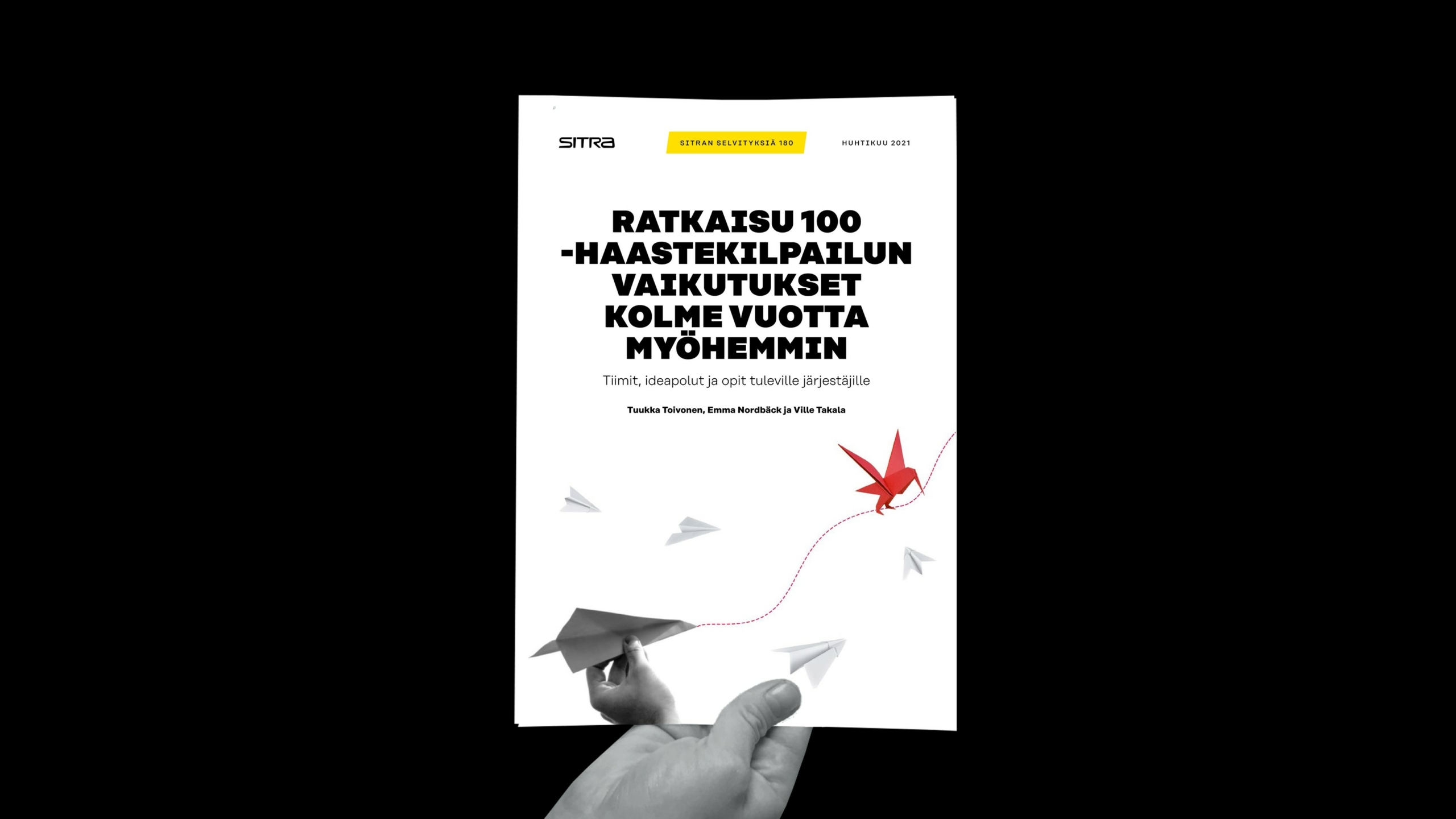 Kädessä on suomenkielinen raportti "Ratkaisu 100 -haastekilpailun vaikutukset kolme vuotta myöhemmin", jossa on kuvia paperilentokoneista ja punaisesta origami-nosturista mustaa taustaa vasten.